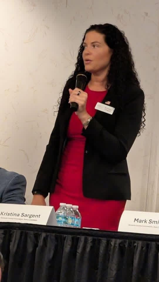 Kristina Sargent speaking on a panel at a District 2 community town hall